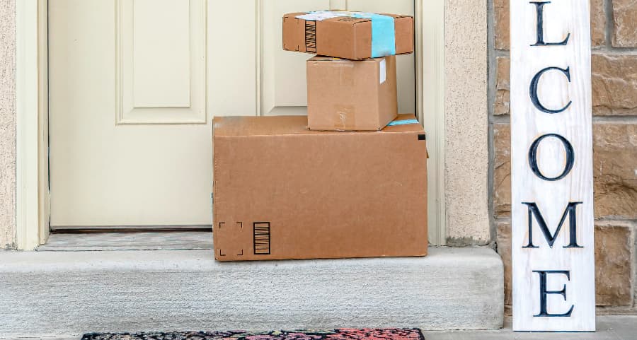 Packages on the doorstep of a home with a welcome sign in Rochester